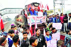 Students stop a train at Rajendra Nagar Terminal in protest against the indefinite strike of non-teaching staff of universities, in Patna on Saturday