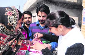 A volunteer administers polio drops to a child during the pulse polio drive in Amritsar on Sunday
