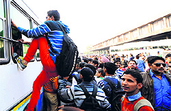 One of the aspiring candidates tries to board a bus from the window at the ISBT, Sector 17, Chandigarh, on Sunday
