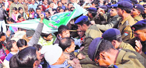 Policemen try to control the protesting shiksha mitras in Dehradun on Saturday.