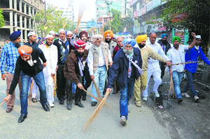 Holding the partys symbol, broom, AAPs Lok Sabha candidate HS Phoolka joins volunteers in cleaning roads during the Jhadoo Chalao Yatra in Ludhiana on Sunday.