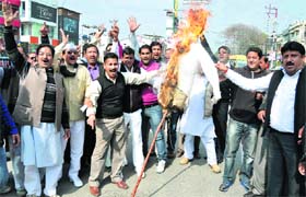 Congress workers burn effigy of BJP leader Ajay Bhatt at Estley Hall Chowk in Dehradun on Monday