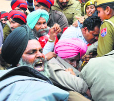 Protesting CITU workers try to break the police cordon at Mini-secretariat in Ludhiana on Monday.