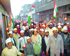 Activists and office-bearers of the Ekta Manch take out a torch march at Mandi Ahmedgarh on Sunday.