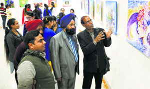 Visitors and artists admire a painting at an art exhibition, titled Rasamanjari, in MS Randhawa Art Gallery, Punjabi Bhawan, on Monday.