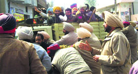 Policemen bundle up protesters in an autorickshaw in Sunam on Monday.