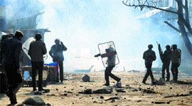Police and CRPF personnel restrain protesters with tear smoke in Kupwara district on Tuesday.