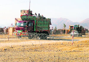 Pakistani tribal families cross a check post as they flee after air strikes on Taliban hideouts, at the exit point of Saidgi village.