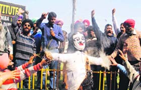Ministerial staff burn the effigy of the state government in Amritsar on Wednesday