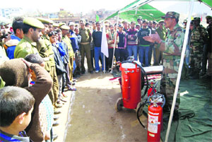 An Army man explains the working of fire extinguishers during a mock drill on disaster management in Doda on Wednesday.