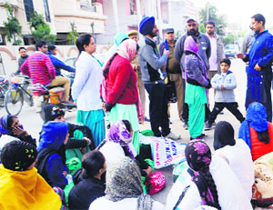 Cabinet Minister Anil Joshi talks to protesting contractual nurses and paramedical workers outside his residence in Amritsar on Thursday.