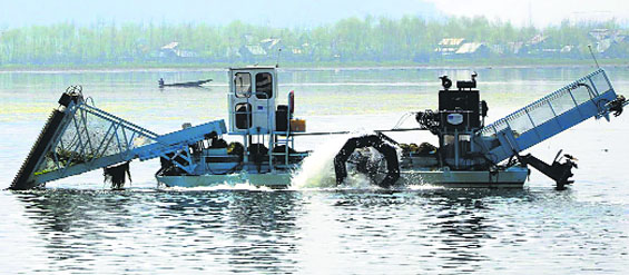 A machine removes weed from Dal Lake in Srinagar on Thursday. Tribune photo: Yawar Kabli