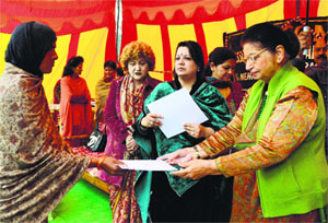 Governor NN Vohra's wife Usha Vohra gives a certificate to a woman at a function at Government Middle School, Simblehar, on Friday. 