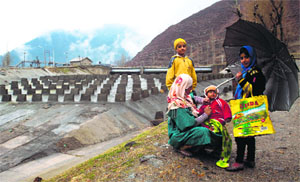 A little girl holds an umbrella as it drizzles in Uri, 100 km west of Srinagar, on Friday
