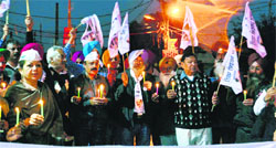 AAP activists hold a candlelight vigil at the Sarabha Nagar Kipps Market in Ludhiana on Friday. photo: Inderjeet Verma