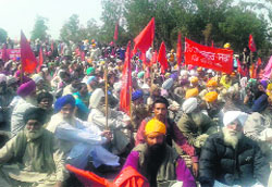 Dehati Majdoor Sabha members block the Amritsar-Jalandhar highway near Rayya on Friday. Tribune photo