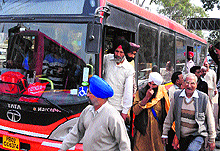 Commuter alight from an overcrowded city bus in Amritsar