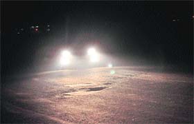 A car moves in the dark on a road dividing Sectors 50 and 51