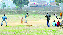 Youth play cricket in an open space