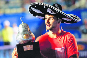 Drimitrov wears a traditional mariachi hat while holding the winners trophy on Sunday