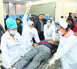 An injured man is pushed at a hospital after a knife attack at Kunming railway station. 