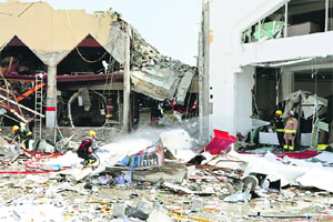 A fire-fighter sprays the site at a Turkish restaurant following a gas explosion in Doha.