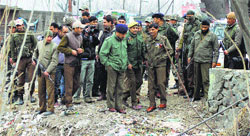Police officers inspect the site where a policeman was stabbed in Pampore on Monday. Tribune photo: Amin War