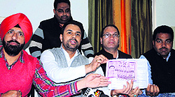 Youth Congress leaders with the Chief Ministers photograph on blue cards issued to BPL families during a press conference in Ammritsar