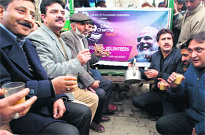 BJP supporters hold cups of tea during a chai per charcha session in Srinagar on Tuesday. 