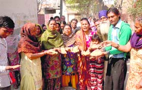 Residents of Naruana Road show the moist and sub-standard wheat that was distributed to them under the Atta-Dal scheme in Bathinda on Wednesday