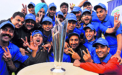 Cricket fans pose with the ICC World Cup T20 trophy at Tau Devi Lal Cricket Stadium in Panchkula