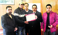 Imran Khan (left), a physically challenged employee of the Srinagar Municipal Corporation, being felicitated by SMC Commissioner GN Qasba in Srinagar on Wednesday