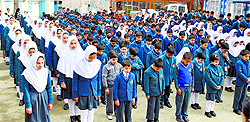 Kashmiri schoolchildren attend assembly on the first day of the school after winter break in south Kashmir's Pulwama district on Wednesday