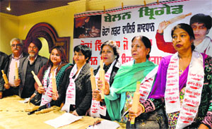 Members of Belan Brigade from the Navkairan Women Welfare Association hold "belans"