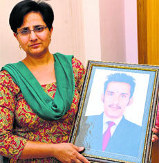Kamlesh Rani holds a picture of her deceased son in Karnal.