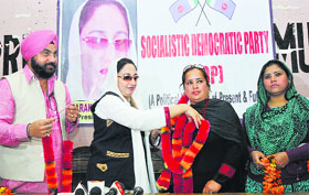 Dr Darakhshan Andrabi, president of the Socialistic Democratic Party, garlands Balwinder Kour after declaring her party candidate from the Jammu (East) Assembly segment in Jammu on Thursday.