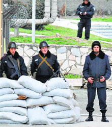 Ukrainian police officers stand guard near the entrance to the police base in Simferopol after it was reinforced on Thursday.