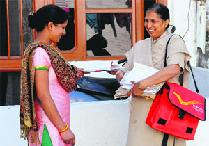 Postwoman Bimla Devi delivers a letter at Sector 19 in Chandigarh.