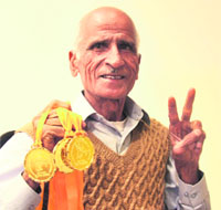 Madan Lal Chitkara, a veteran athlete, shows 3 gold medals won by him in an athletics meet.
