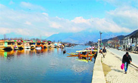 Men walk on the footpath of the Dal Lake during a sunny day in Srinagar.