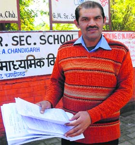 Rajesh Dutta, a resident of Sector 22, shows the enrolment forms he got photocopied from the market in Chandigarh on Saturday