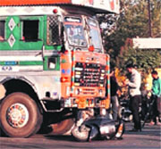 Passersby stand near the damaged scooter and the truck on Ferozepur Road in Ludhiana on Saturday. A Tribune Photograph
