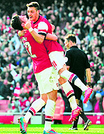 Olivier Giroud and Mesut Ozil celebrate Arsenals fourth goal against Everton in their FA Cup quarterfinal in London on Saturday