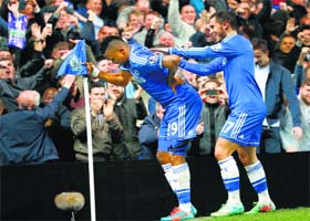 Samuel Eto'o celebrates his 300th career goal by bending over the corner flag like an old man, a nod to controversy about Jose Mourinhos comments on his age