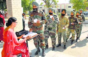 Army personnel line up outside a polling booth in Jalandhar cantonment