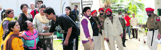 Wailing family members of the 19-year-old boy found dead in a private hospital; and (right) Policemen on the hospital premises where the youth was found dead in Amritsar on Monday.