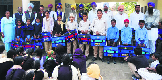 Guru Gobind Singh Refinery officials distribute bags and stationary to students in Bathinda on Monday. A Tribune photograph