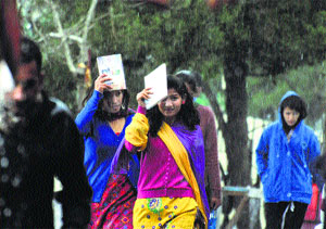 Girls walk in the rain at Himachal Pradesh University in Shimla on Monday.