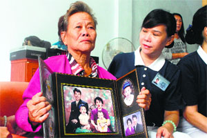 An Indonesian woman shows a portrait of her son and his wife, both passengers of the missing Malaysia Airlines flight MH370, in Sumatra on Monday. 