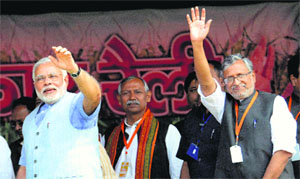 BJPs PM candidate Narendra Modi and party leader Sushil Modi wave at crowd during Hunkar Rally in Purnea, Bihar, on Monday.